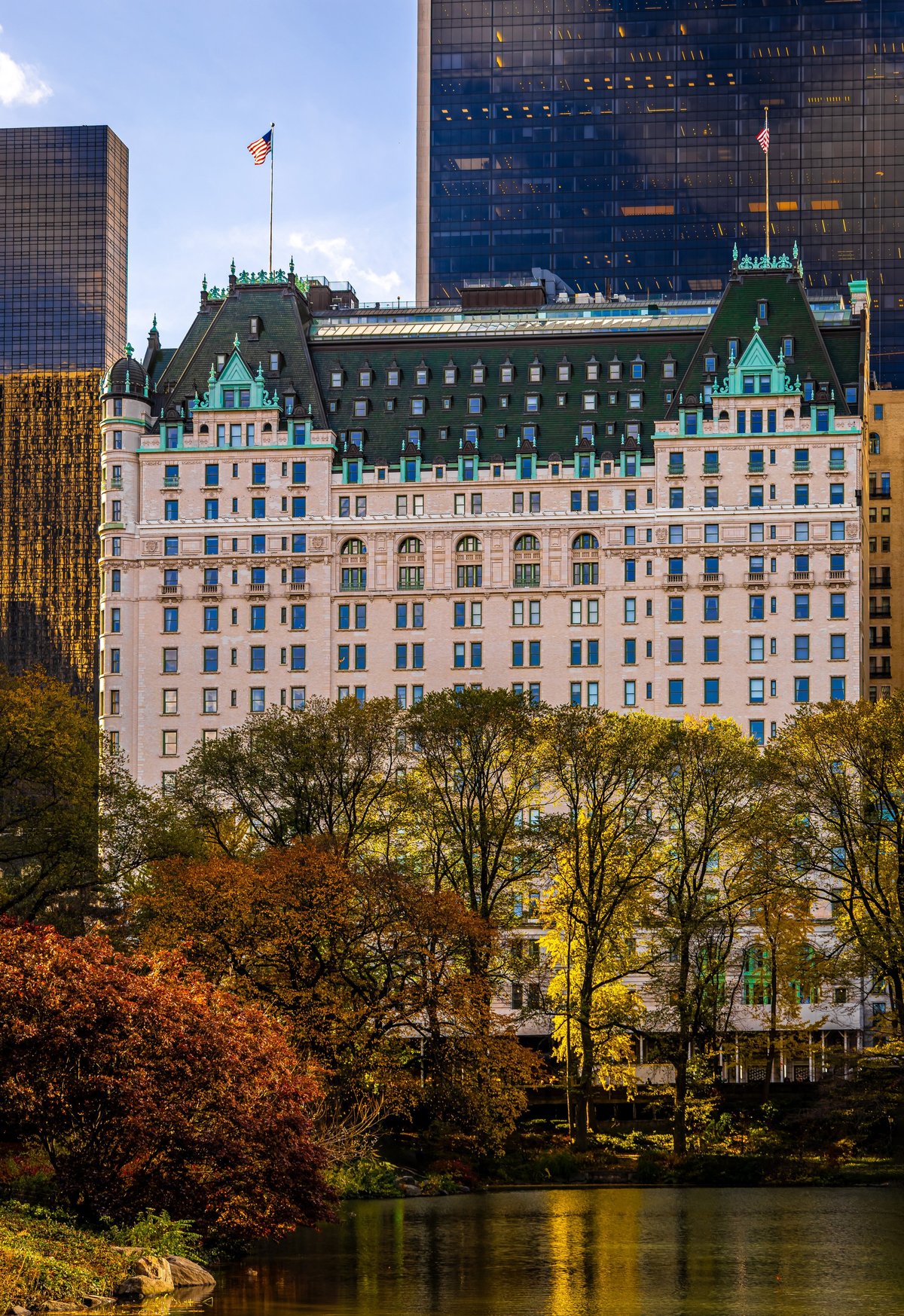 The Plaza Hotel rises behind vivid fall foliage at the edge of Central Park in Manhattan, New York City; ideal for travel ads, luxury hospitality, real estate, and editorial use