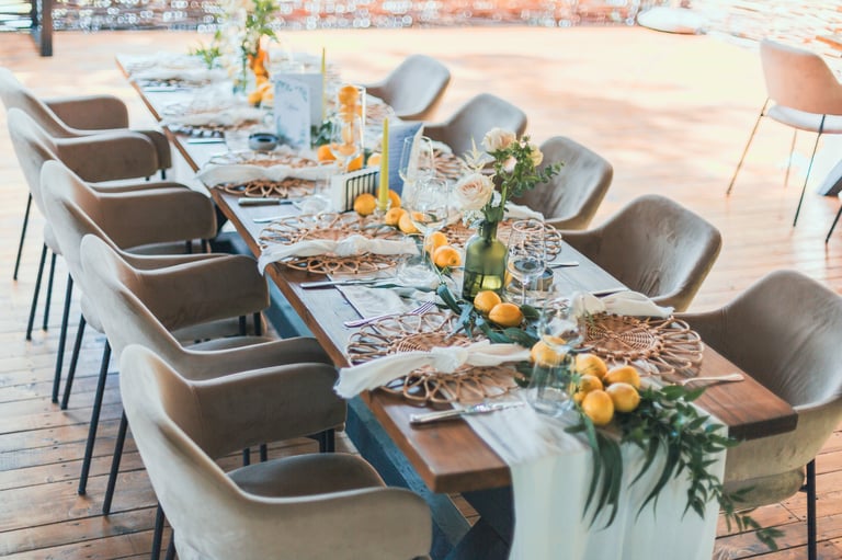 Elegant wedding table setup featuring citrus fruits, greenery, and delicate floral arrangement.